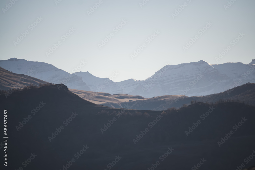 Panorama of a mountain landscape with slopes and ridges in the distance on a sunny autumn morning minimalism, tonal perspective of mountain ranges