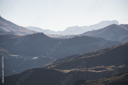 Panorama of a mountain landscape with slopes and ridges in the distance on a sunny autumn morning minimalism, tonal perspective of mountain ranges photo