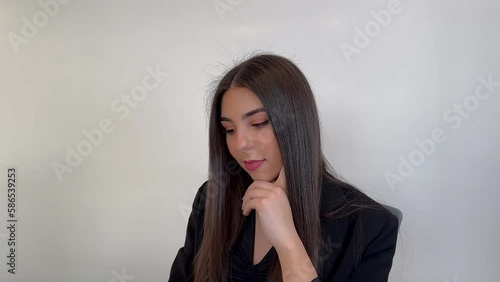 Happy young woman sitting in her office and working on a laptop