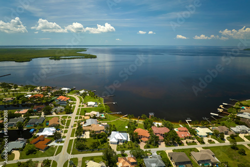 Aerial view of residential suburbs with private homes located on gulf coast near wildlife wetlands with green vegetation on sea shore. Living close to nature concept © bilanol