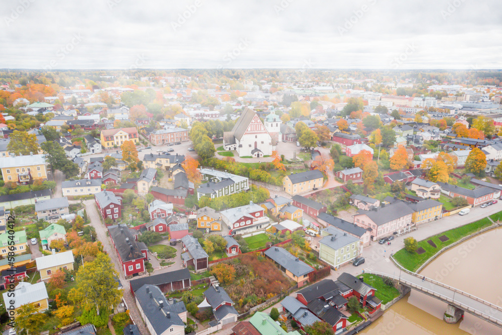 Aerial autumn foggy view of Old town of Porvoo, Finland. Beautiful city landscape with idyllic river Porvoonjoki, old colorful wooden buildings and Porvoo Cathedral.