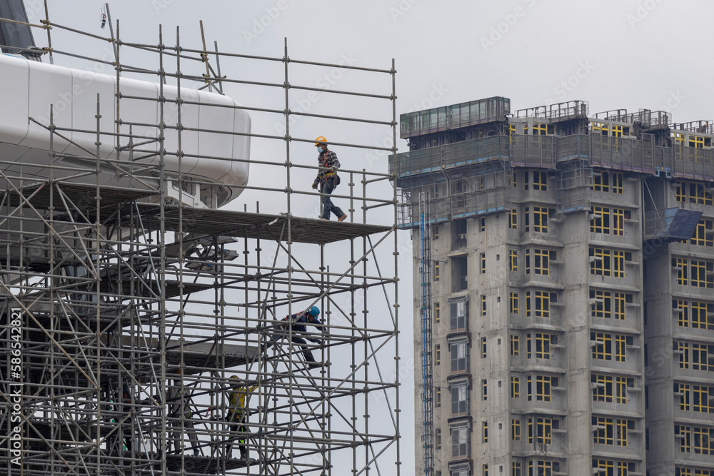2023 Mar 29,Hong Kong.Workers working on scaffolding of building