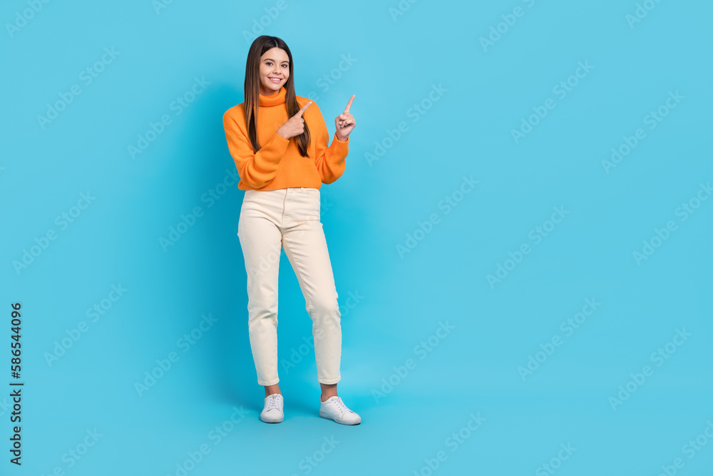 Full length photo of cheerful nice person indicate fingers empty space isolated on blue color background Full length photo of cheerful nice person indicate fingers empty space isolated on blue color background