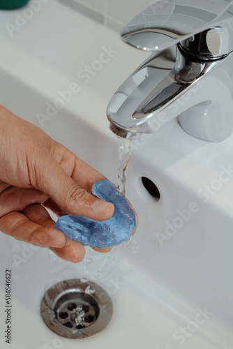 man rinsing his occlusal splint