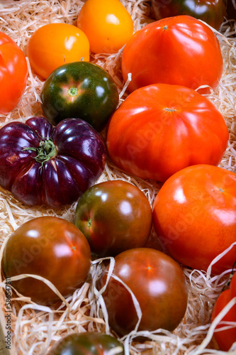 Variety of tasty ripe french tomatoes in wooden boxes on farmers market in Provence in summer photo