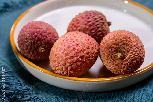 Tasty tropical exotic fruits, ripe fresh unpeeled lychee fruits