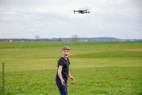 A frightened boy got stressed when he saw a quadcopter in the field.