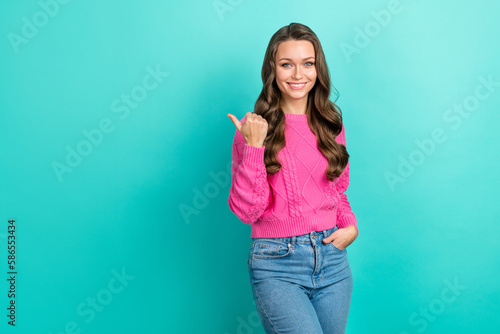 Portrait of cheerful stunning lady wear pink sweater thump presenting empty space opening store isolated on cyan color background
