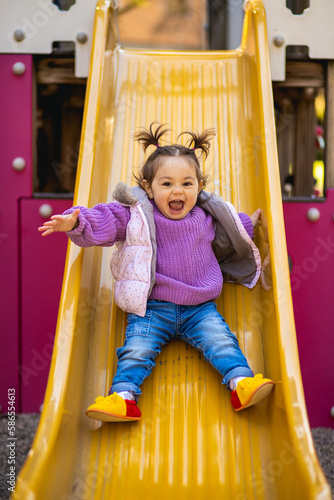 Fotografie Sweet caucasian little toddler girl with two tails having fun smiling widely sli