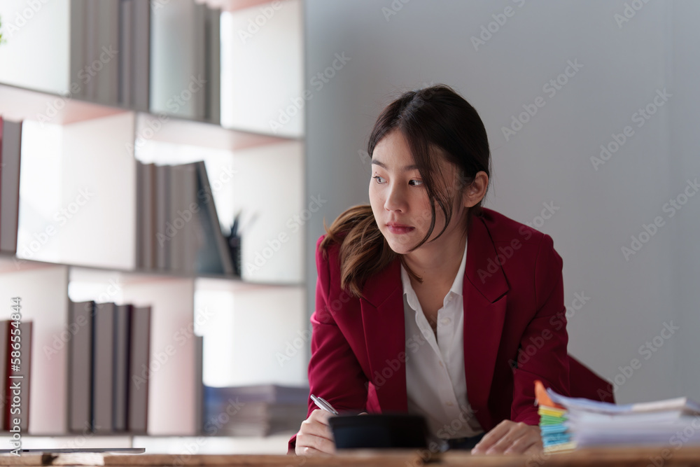 Smiling Asian Banker makes financial report and studies annual figures, analyzes profits. Accountant checks status of financial Smiling Asian Banker makes financial report and studies annual figures, analyzes profits. Accountant checks status of financial