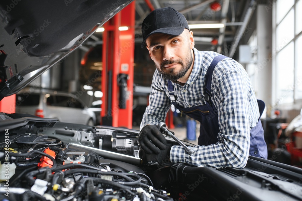 Professional Mechanic is Working on a Car in a Car Service. Professional Mechanic is Working on a Car in a Car Service.