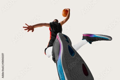 Fotografie A fisheye view of male professional basketball player jumping and throwing ball