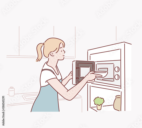 Woman cooking with a microwave in a modern kitchen. Hand drawn style vector design illustrations.