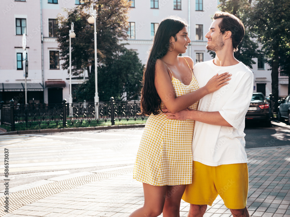 Smiling beautiful woman and her handsome boyfriend. Happy cheerful family. Sexy couple posing in the street at sunrise. During romantic date at sunny summer day outdoors. Looking at each other