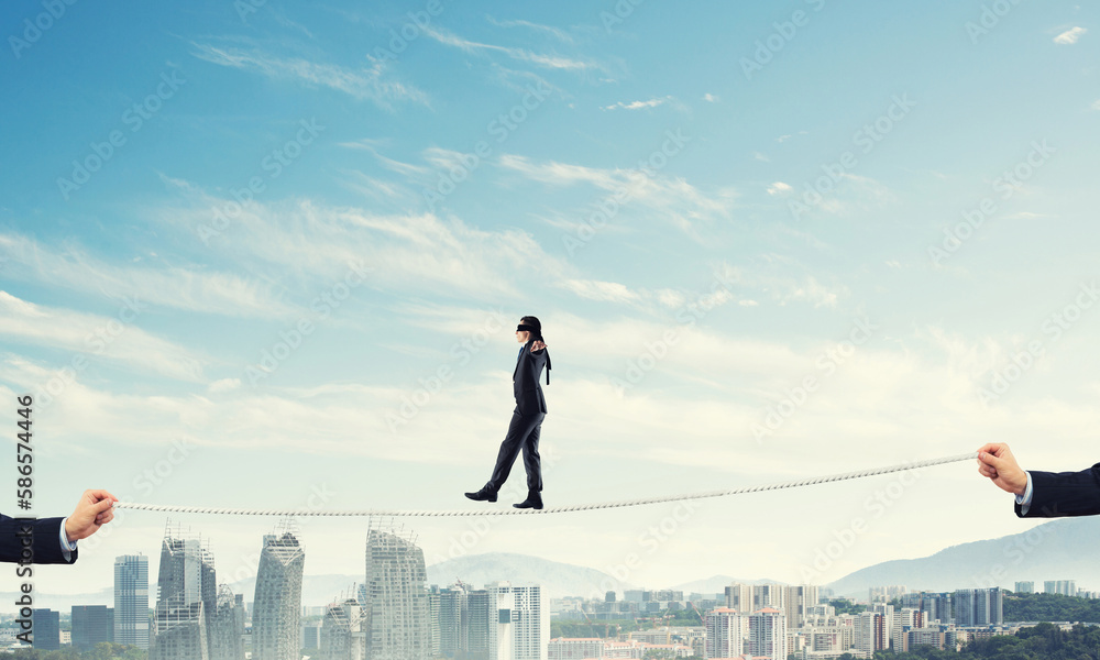 Business concept of risk support and assistance with man balancing on rope Business concept of risk support and assistance with man balancing on rope