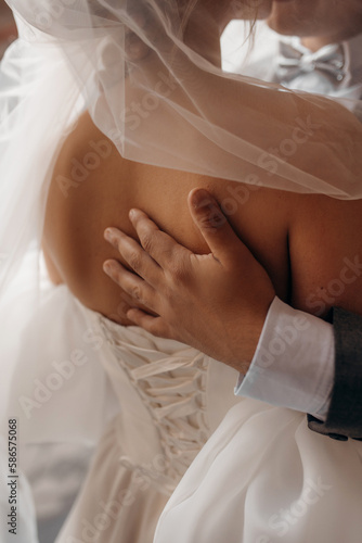 Strong hugs of a loving couple. Close up of boy's hands. A man sensually and tenderly holds a woman in his arms.