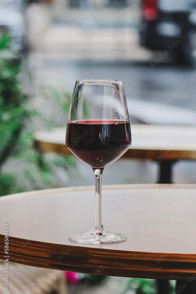 A glass of red wine on the summer terrace of a Parisian restaurant A glass of red wine on the summer terrace of a Parisian restaurant