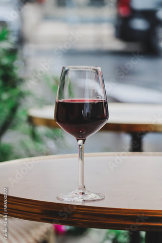 A glass of red wine on the summer terrace of a Parisian restaurant