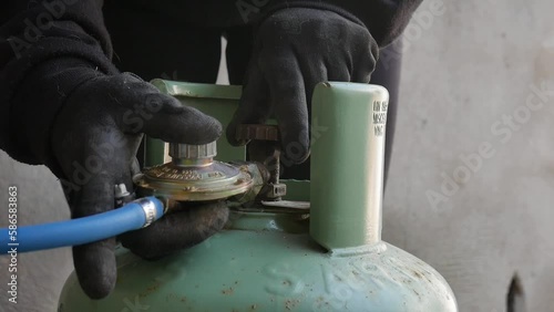 LPG cylinder connection with pressure regulator. close-up of a technician connecting a gas cylinder. pvc pipe. bottle sealed and ready to use.