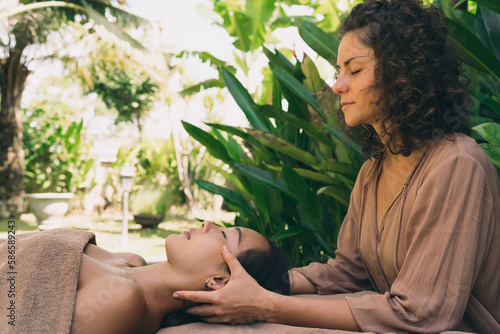 Valokuva Asian woman relaxing during spa procedure with Caucasian beautician professional