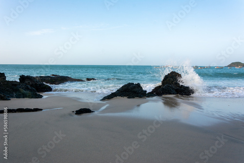 Sea crashing against the stones. Beach shore. Sea with foam