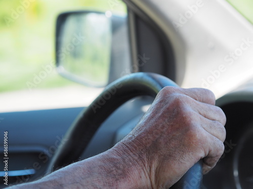 Farmer driving in the freeway. Hands on the steering wheel.