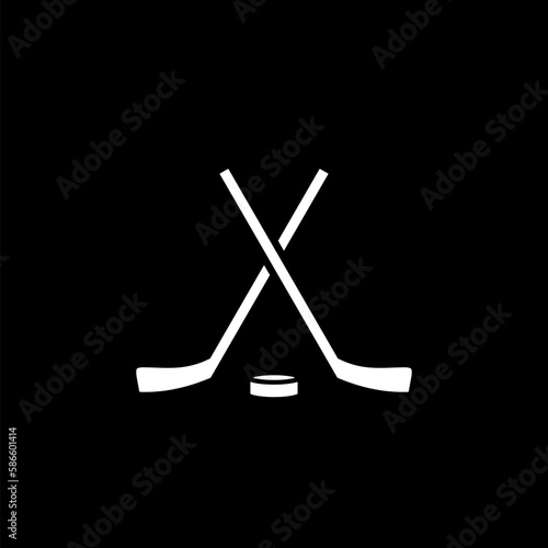 Crossed hockey sticks and hockey puck isolated on black background.