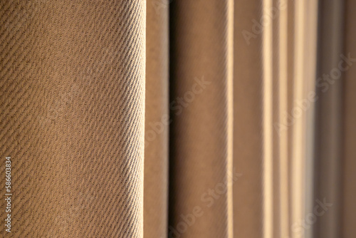 The wave of soft brown window curtains. curtain with morning light from window, curtain streaks. Fabric curtain wavy background. Selective focus. copy space © somchairakin