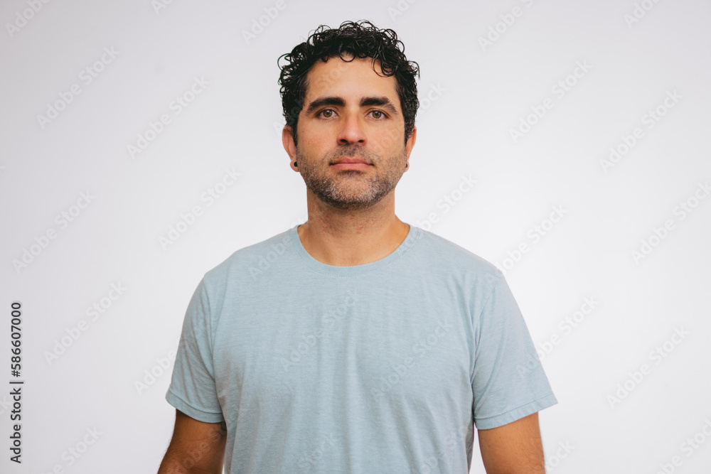 Middle-aged man in a T-shirt looking blankly at the camera against a white background. Middle-aged man in a T-shirt looking blankly at the camera against a white background.