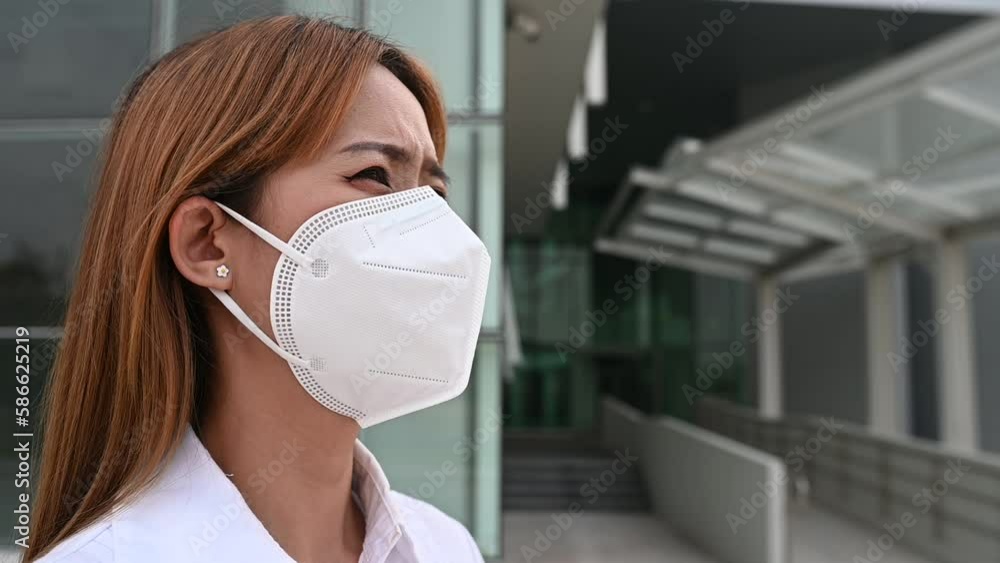 Asian woman wear N95 mask for protect dust pm 2.5,ecology concept. Allergy, headache. air danger in city. Asian woman wear N95 mask for protect dust pm 2.5,ecology concept. Allergy, headache. air danger in city.