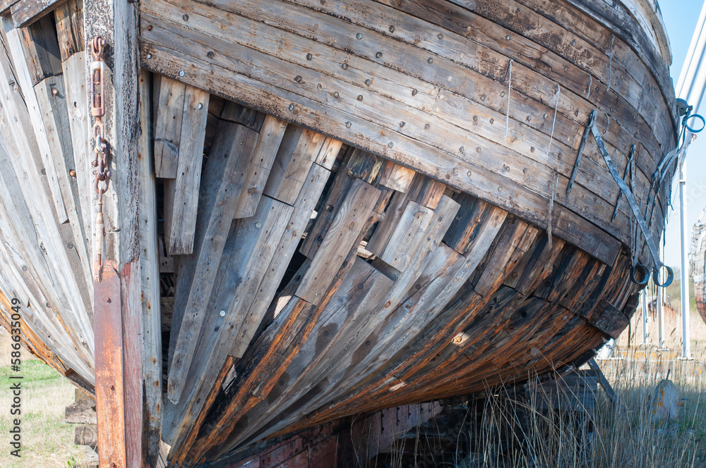 Old derelict wooden ship wreck closeup. Front side of an old abandoned boat coastline In Estonia Old derelict wooden ship wreck closeup. Front side of an old abandoned boat coastline In Estonia