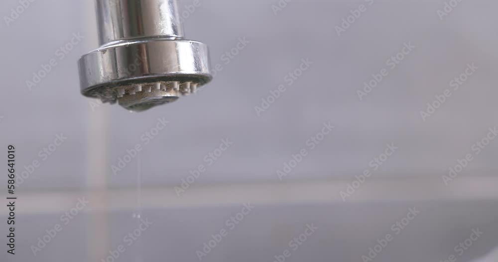 Drops fall from a leaking tap in the bathroom. Drops fall from a leaking tap in the bathroom.