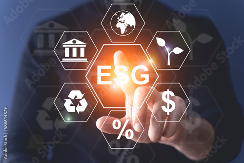 Global ESG technology concept. Man's hand presses a holographic button. Environmental, Social, and Corporate Governance idea. 