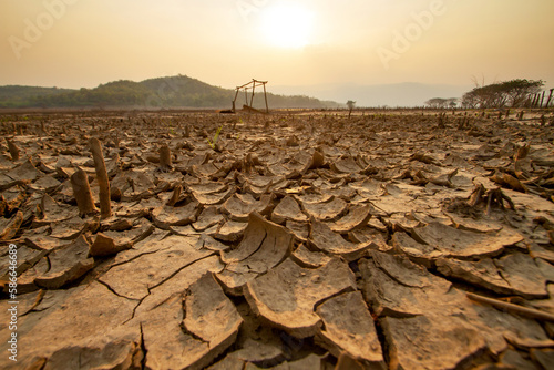 Landscape Dry cracked earth with dead crop plant at agriculture fields. High temperature and heatwave on summer exacerbate drought, impact to agricultural.