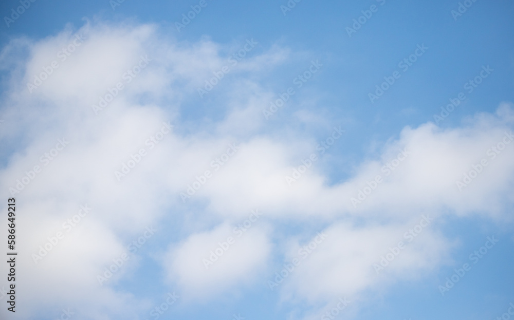 Blue sky with white fluffy clouds in sunny weather.