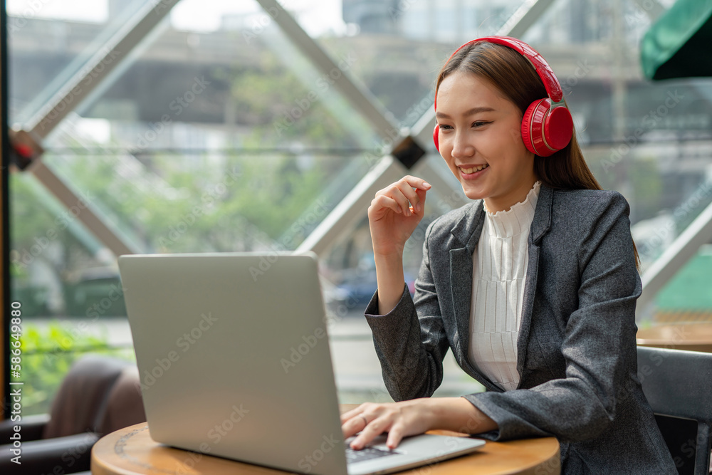 Young asian businesswoman working on her computer laptop and wearing a ...