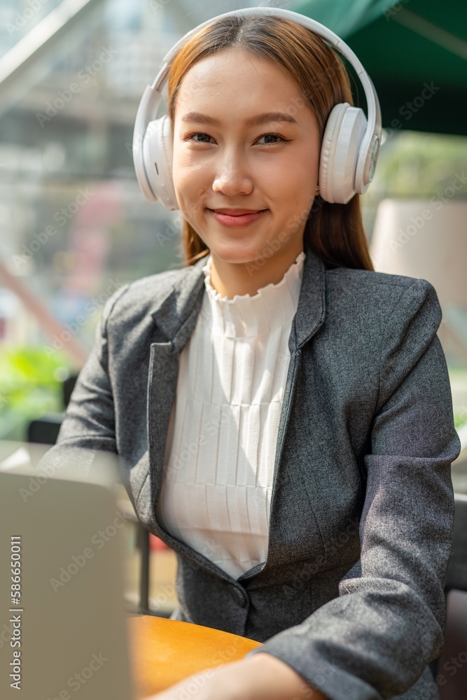 Young asian businesswoman working on her computer laptop and wearing a ...