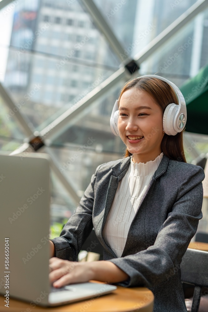 Young asian businesswoman working on her computer laptop and wearing a ...