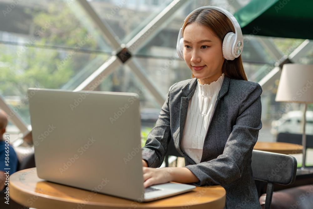 Young asian businesswoman working on her computer laptop and wearing a ...
