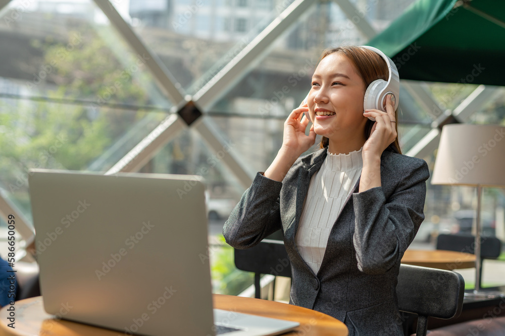 Young asian businesswoman working on her computer laptop and wearing a ...