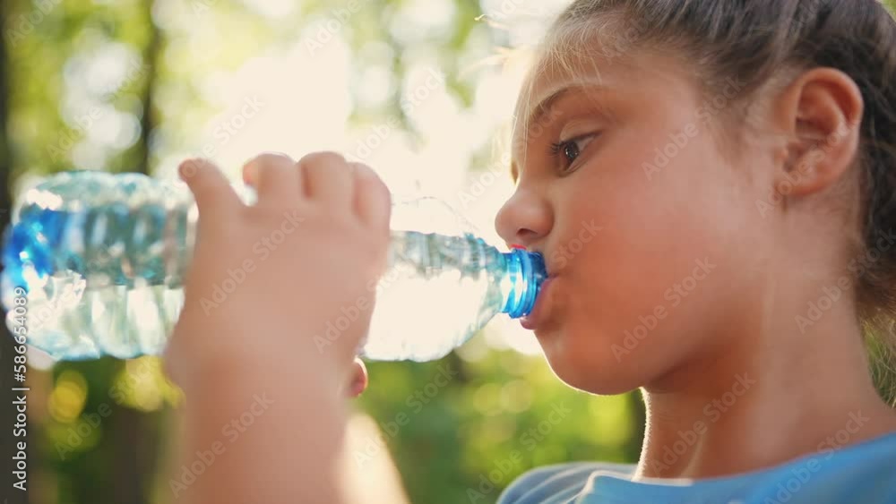 child drinking water from a plastic bottle. water shortage problem on earth concept lifestyle. water shortage problem on earth concept. kid drinks water in nature from a bottle glare of the sun summer child drinking water from a plastic bottle. water shortage problem on earth concept lifestyle. water shortage problem on earth concept. kid drinks water in nature from a bottle glare of the sun summer