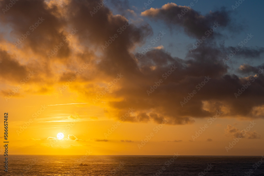 Seascape at sunset - yellow sun is setting down on the horizon