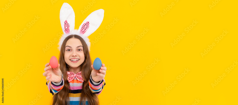 cheerful kid in bunny ears and bow tie hold easter eggs on yellow background. Easter child horizontal poster. Web banner header of bunny kid, copy space. cheerful kid in bunny ears and bow tie hold easter eggs on yellow background. Easter child horizontal poster. Web banner header of bunny kid, copy space.