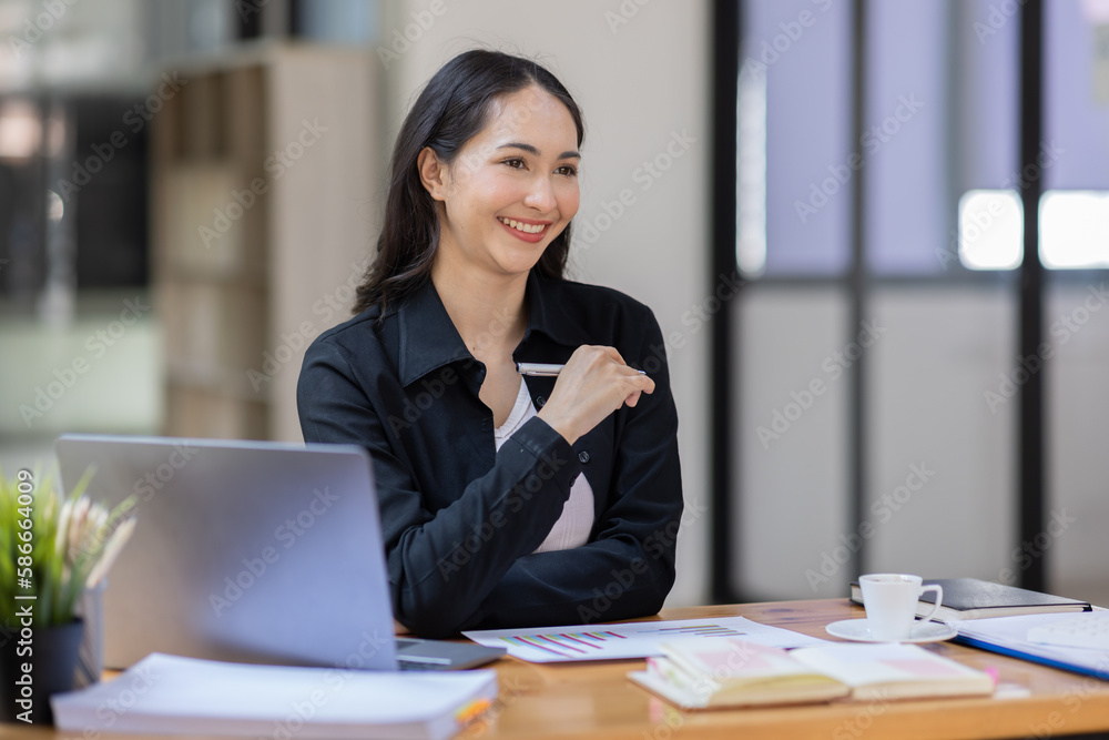 Portrait of business asian woman working on laptop in her workplace. asian smile business lady employee working on laptop in office finance business concept. Portrait of business asian woman working on laptop in her workplace. asian smile business lady employee working on laptop in office finance business concept.