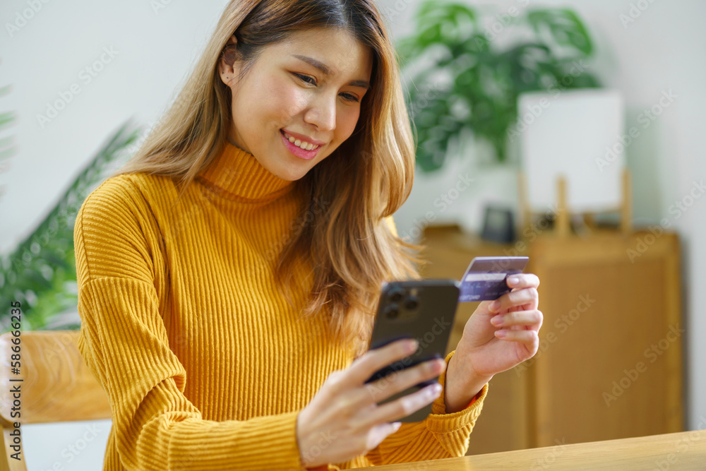 Fototapeta premium Woman shopping&nbsp;on laptop holding credit card for Internet online e-commerce shopping spending money Online shopping Mobile phone laptop technology concept