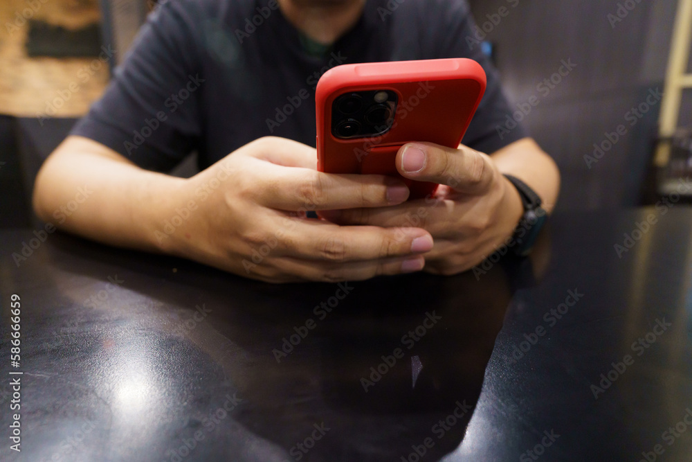 Man playing game on mobile phone. gamer boy playing video games holding Smartphone working mobile devices. cell telephone technology e-commerce concept. Man playing game on mobile phone. gamer boy playing video games holding Smartphone working mobile devices. cell telephone technology e-commerce concept.