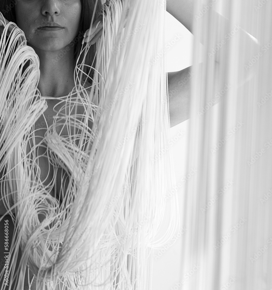body and part of portrait of a young gorgeous woman, attractive, sexy, naked, partially obscured by the white threads of a falling string curtain in beautiful shapes. body and part of portrait of a young gorgeous woman, attractive, sexy, naked, partially obscured by the white threads of a falling string curtain in beautiful shapes.