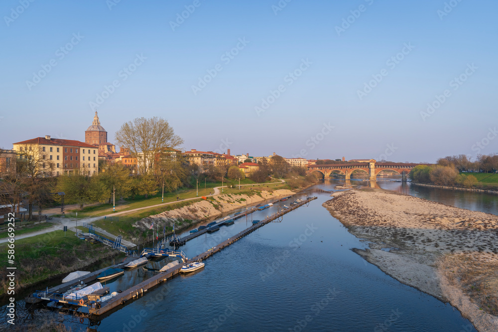 Skyline of Pavia , Ponte Coperto(covered bridge) is a bridge over the Ticino river in Pavia at sunny day, Pavia Cathedral background, Italy