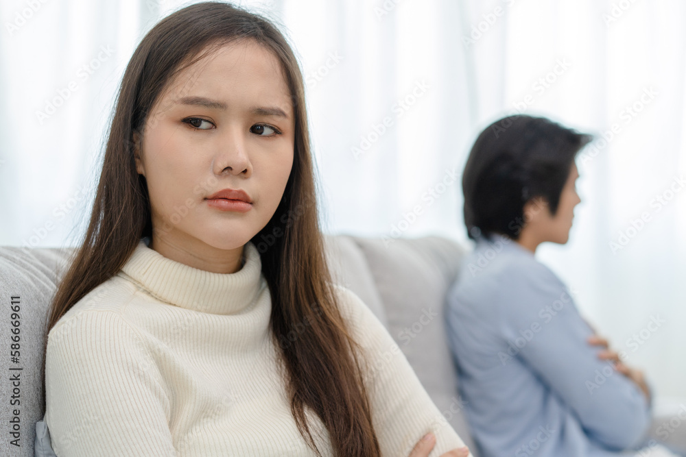 Family problems, Asian women cover her face and sit separately from husband feel disappointed after quarrels at home. Family problems, Asian women cover her face and sit separately from husband feel disappointed after quarrels at home.