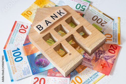 Miniature bank of switzerland and a bundle of swiss francs, business concept, banking business, financial stabilization, lending, foreign exchange market